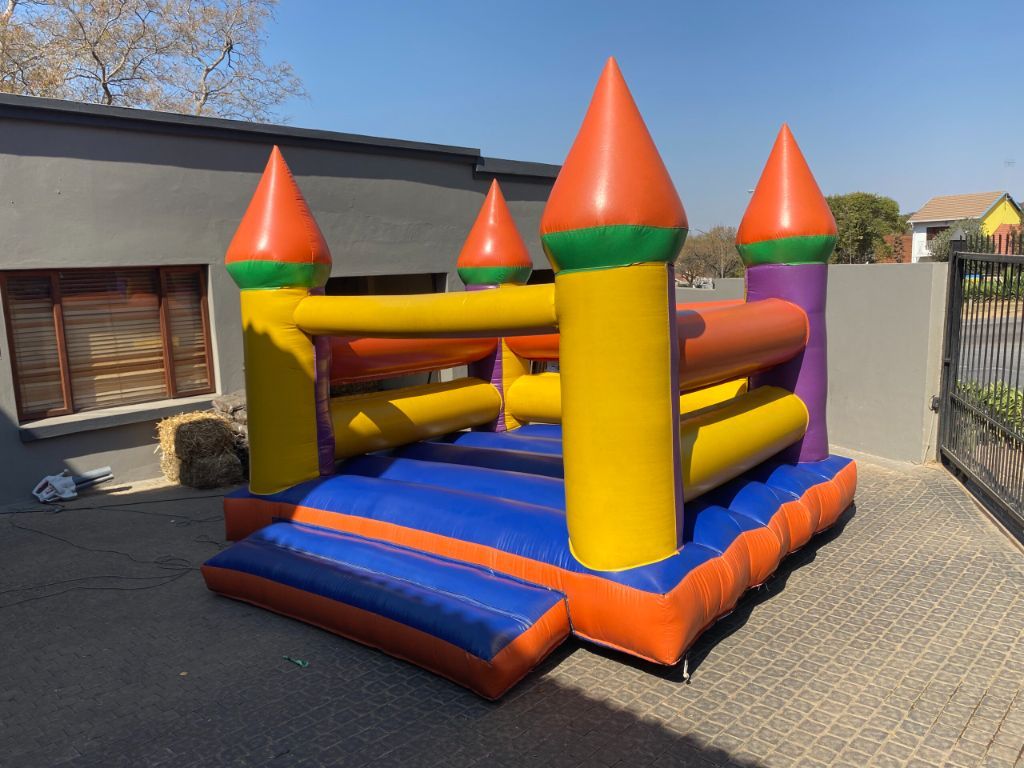 Classic multi-colored jumping castle with turrets for party hire